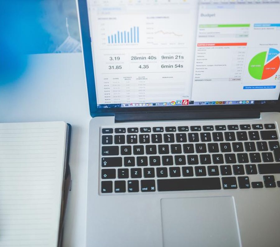 Estação de trabalho com laptop exibindo dashboards